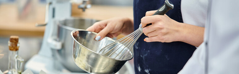 cropped view of young female chef whisking ingredients next to chief cook, confectionery, banner