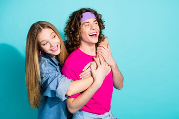 Wall Mural - Portrait of two young teenage people lovers wear pink t shirt and denim laughing cuddling isolated on aquamarine color background