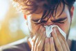 Allergic man sneezing covering nose with handkerchief. 