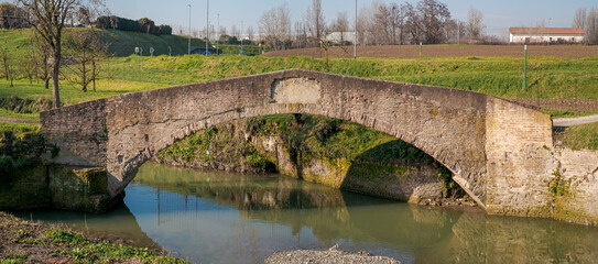 Antique pedestrian bridge, called Ponte della Bionda, on the Navile canal: historic waterway of Bologna. Emilia Romagna, Italy