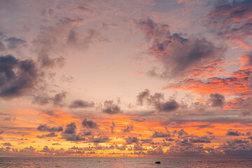 Wall Mural - Sunset over the water with clouds against the sunlight on the Andaman Sea, Patong, Phuket, Thailand.