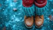  a close up of a person's feet wearing a pair of brown and blue knitted mittens and a pair of brown and blue knitted boots in the snow.