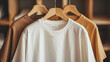 © Serega - a row of white, beige, and brown tee shirts hanging