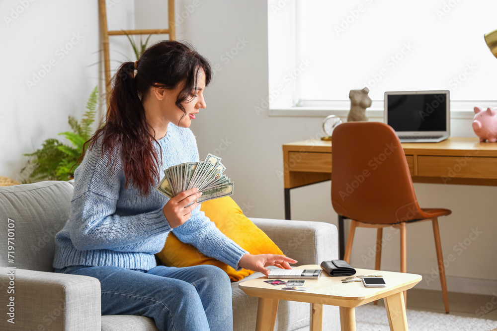 Young woman counting money  at home