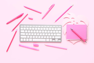 Poster - Composition with modern computer keyboard, notebook, pens and pencils on pink background