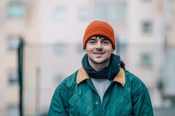 Wall Mural - portrait of young man on the street in winter warm and wearing a hat