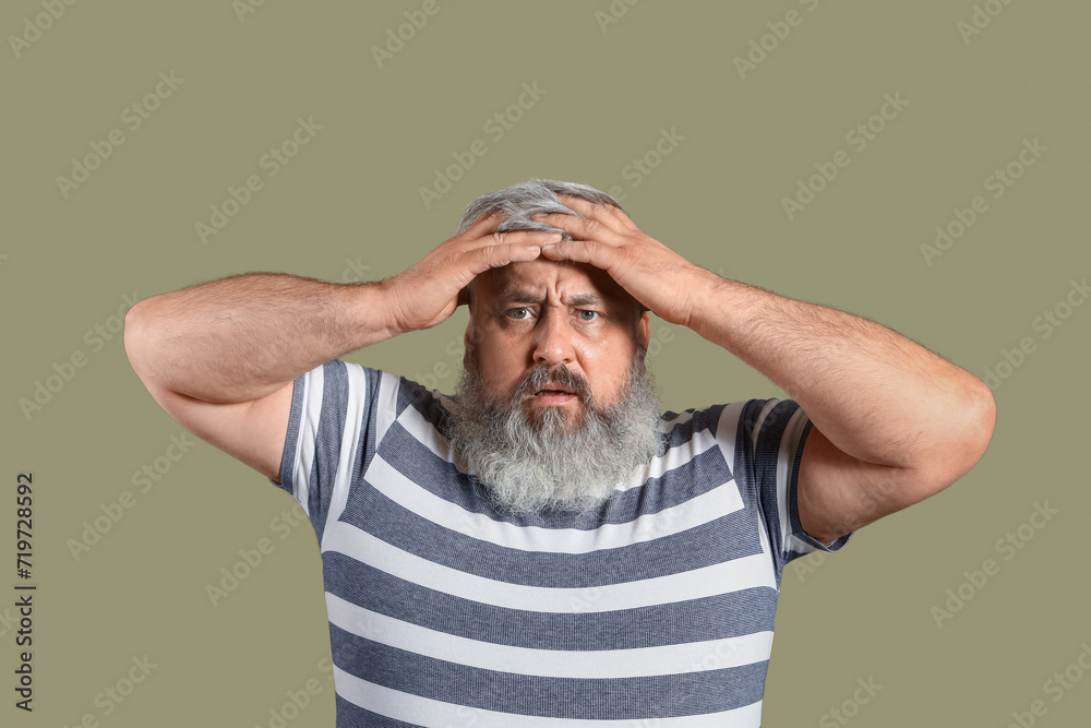 Afraid mature man on green background