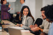 © Zamrznuti tonovi - Smiling woman with headset laughing with her multiracial colleagues in an office