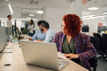 A call center worker is sitting at workplace with headset.