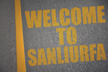 asphalt road with text welcome to Sanliurfa near yellow line.