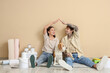 © Pixel-Shot - Young couple with Beagle dog and painting tools making roof gesture during repair in their new house