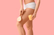 © Pixel-Shot - Beautiful young woman with cellulite problem, massage brush and jar of body scrub on pink background