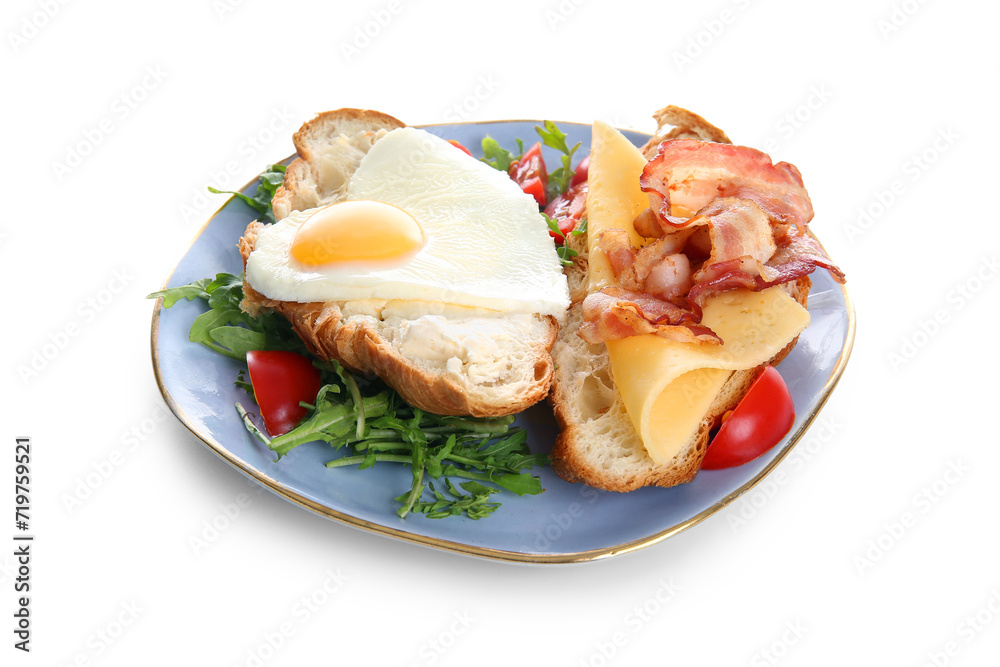 Plate with tasty fried egg, cut croissant, bacon, tomatoes and arugula on white background