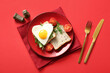 Leinwandbild Motiv Plate with tasty fried egg, toasts, tomatoes and arugula on red background