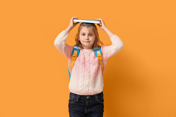 Canvas Print - Little schoolgirl with book on yellow background