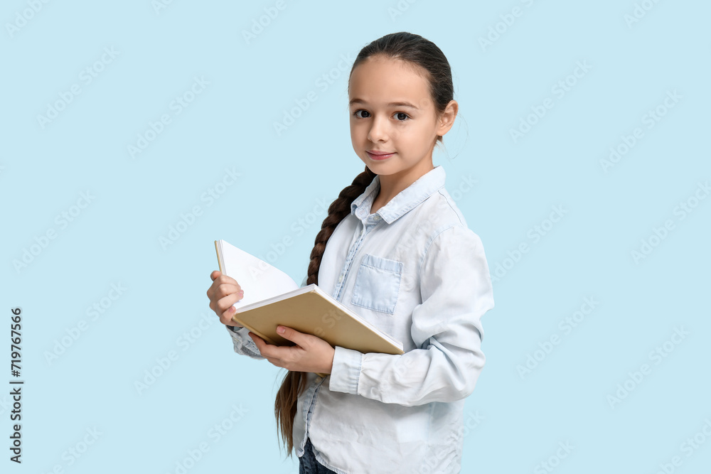 Little girl reading book on  blue background