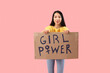 Beautiful young Asian woman holding paper with text GIRL POWER on pink background. Women history month
