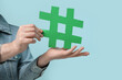 © Pixel-Shot - Man with hashtag sign on blue background