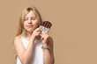 © Pixel-Shot - Cute little girl with sweet chocolate bar on brown background