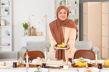 Wall Mural - Mature Muslim woman setting table for dinner at home. Ramadan celebration