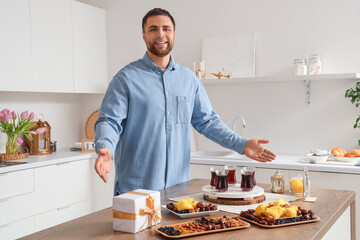 Wall Mural - Young Muslim man celebrating Ramadan at table in kitchen