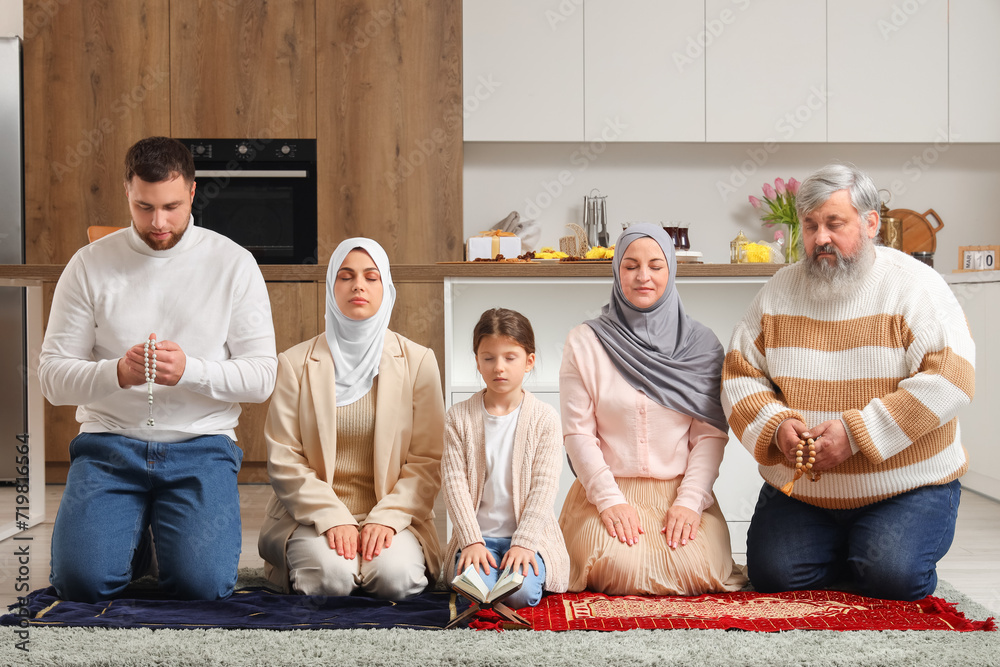 Happy Muslim family praying in kitchen. Ramadan celebration
