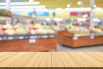 Wall Mural - Empty wood table top with supermarket blurred background for product display