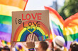 © AI Visual Vault - Rainbow Heart Sign Proclaiming Love at Pride Event.A vibrant hand-held sign reading 'LOVE is LOVE' with a rainbow heart at a pride parade.