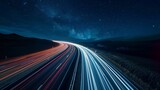 Fototapeta  - The remote road is transformed into a magical journey through the stars thanks to the dramatic and captivating light trails left in the wake of ping cars.