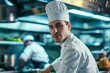 © RDO - Professional male chef in a white chef's coat and hat, with a busy, high-end kitchen scene behind him