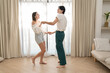 © Hip.hub - Beautiful young people dancing at home. Valentine's Day concept. Lovers at home celebrating Valentine's Day.