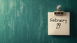 © Keitma - Note on green wall background with written February 29 as a reminder for leap year day with copy space
