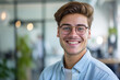 Cheerful Entrepreneur Portrait. Smiling young man with glasses, bright office backdrop.