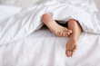 © Cameron Mcdonald/peopleimages.com - Bed, feet and person sleeping in home, relax and resting nap in sheets for health, calm and leisure in the morning. Foot, bedroom and closeup of toes in blanket, skin of legs and comfort in house