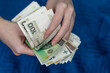 Kobieta trzyma w dłoniach pieniądze, liczy polskie banknoty