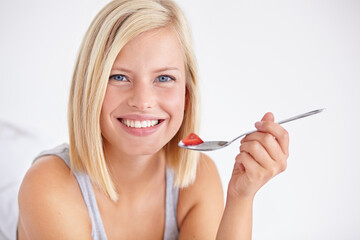 Wall Mural - Portrait, happy woman and eating fruit salad, healthy diet or nutrition in home bedroom. Face smile, spoon or person with strawberry, hungry for breakfast or organic food for wellness in the morning