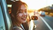 © Naknakhone - Young beautiful asian women getting new car. she very happy and excited. Smiling female driving vehicle on the road on a bright day. Copy space for text.