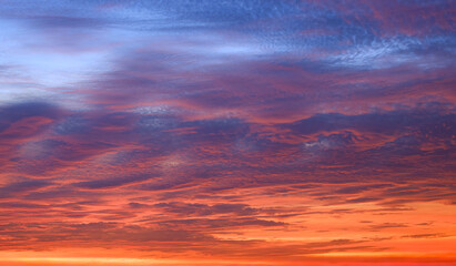 Wall Mural - Dramatic storm clouds on dusk sky background with colorful orange sunlight cloudy on dark blue evening sky