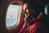 Fototapeta  - smile man in red zip-up jacket and sweater sitting in seat in airplane and looking out window