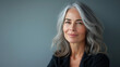 © MNFTs - Beautiful woman with grey hair smiling posing on grey background.