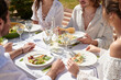 © Just images - Summer Luncheon in White. A group of friends enjoy a sumptuous summer luncheon outdoors, with white wine and a variety of salads, celebrating togetherness under the bright sunlight.