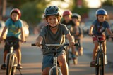 A group of young boys, with their helmets on and clothes fluttering in the wind, joyfully pedal their bicycles along the road, their wheels spinning and handlebars firmly gripped as they embrace the 