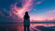 Silhouette of a woman on the beach staring at the dreamy colorful sky.