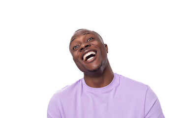 Wall Mural - close-up portrait of a young laughing african man in a lilac t-shirt making a grimace