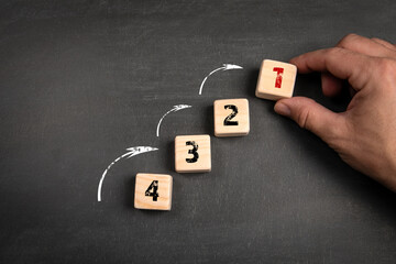 Wall Mural - Competition and development concept. Wooden blocks on a dark chalkboard background