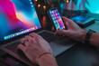 © Yi_Studio - sitting on laptop and hands holding a cellphone
