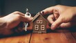 Close up of businessman's hands holding house model with keys.  Sale, business investment and home insurance concept