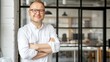 © Ilja - Bright office meeting, happy businessman portrait on blurred glass walls, space for text placement