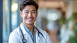 © aekkorn - Medicine and healthcare concept : Portrait of smiling Asian male doctor standing in corridor with big windows at hospital. Doctor with stethoscope. 16:9 Ratio with copy space.