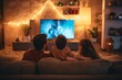 © Romana - a family sitting in front of a huge flat screen television in the living-room in the evening watching a movie spending leisure time together